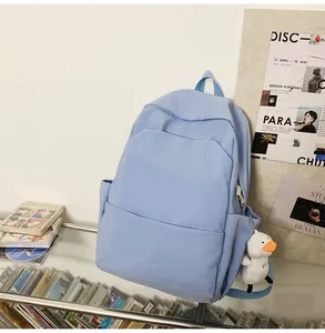 Detail of light blue waterproof backpack featuring a cute plush duck charm for students