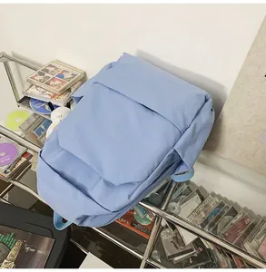 Detail shot of a light blue waterproof nylon backpack in a cozy study setting with books