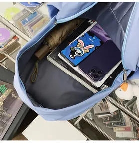 Interior view showing the large capacity of the light blue backpack with various items