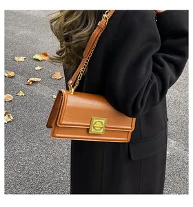 Detail of caramel PU leather crossbody bag with vintage gold buckle and chain strap