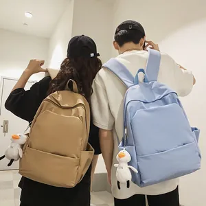 Minimalist waterproof large capacity backpacks in khaki and light blue with duck pendant