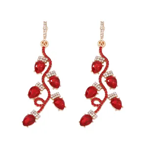 Détail de boucles d'oreilles feuilles en alliage doré avec cristaux colorés de fête