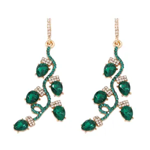 Détail des boucles d'oreilles de Noël avec gemmes vertes et cristaux blancs étincelants