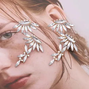 Elegant silver leaf flower earrings with sparkling rhinestones on a female portrait background