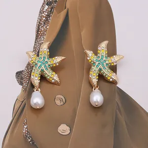 Detailed shot of starfish earrings with colorful rhinestones and teardrop pearl drops