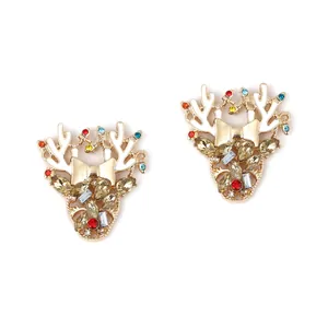 Dettaglio degli orecchini a renna di Natale con strass colorati e fiocco in lega dorata