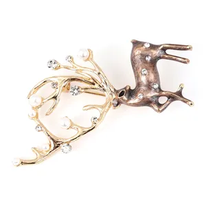 Elegante broche de reno con astas doradas, perlas blancas y cristales sobre cuerpo bronce