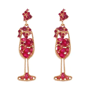 Vintage rose gold wine glass earrings with pearls and red crystals on white background