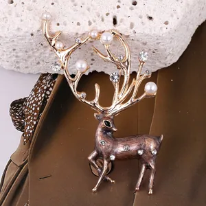 Broche de reno dorado con perlas y cristales sobre fondo de piedra texturizada elegante