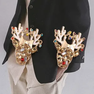 Spille natalizie a forma di renna dorata con strass colorati su colletto di camicia