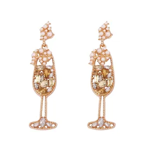 Macro view of vintage wine glass earrings with amber rhinestones and white pearls