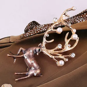 Primer plano detallado de broche de reno vintage en bronce con perlas y cristales brillantes