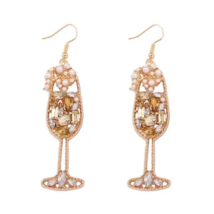 Detailed view of champagne glass earrings with amber crystals and white pearls