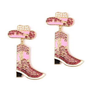 Detail of pink rhinestone cowboy boot and pearl hat dangle earrings in gold finish