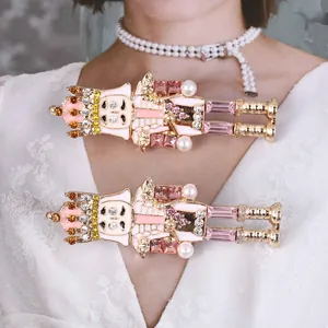 Dettaglio di spille schiaccianoci con smalto rosa e strass scintillanti