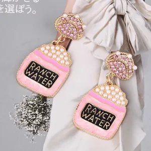 Gros plan détaillé de boucles d'oreilles tasse à thé rose avec cristaux et perles