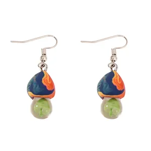 Detail of mushroom earrings with colorful painted caps and miniature resin mushrooms