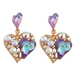 Elegante goldene Herzohrringe mit lila und blauen Kristallen in symmetrischer Ansicht