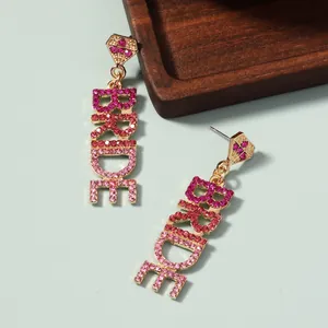 Makroaufnahme der goldenen Legierung BRIDE-Ohrhänger mit rosa Strasssteinen für Hochzeiten