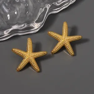 Golden starfish stud earrings with detailed bead texture on a minimalist background