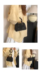 Detail of black beaded shell bag with gold double zippers and elegant chain strap