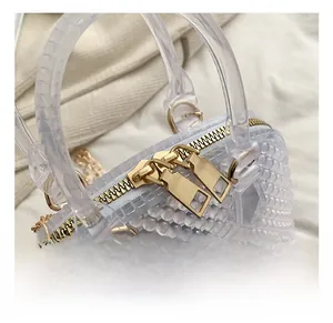 Close-up of transparent PVC shell bag with 3D bead details and golden metal zipper