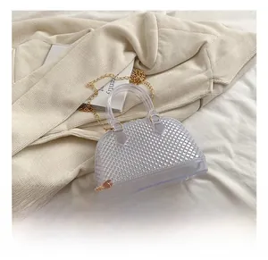 Close-up of transparent jelly shell bag with diamond texture and gold chain strap
