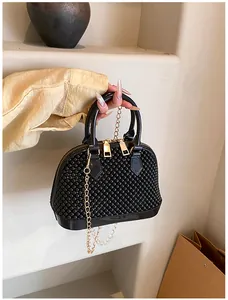 Detailed view of black beaded shell bag with gold chain and smooth leather trim