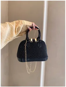 Detail of black jelly shell bag featuring studded bead texture and gold chain strap