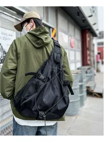 Detail view of black techwear crossbody bag with adjustable buckles and mesh pocket