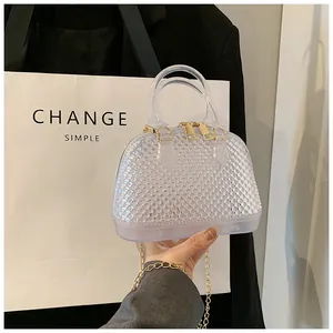 Close-up of transparent jelly shell bag with beaded texture and golden chain strap