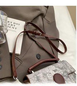 Detail of vintage handbag with landscape print and smooth adjustable leather shoulder strap