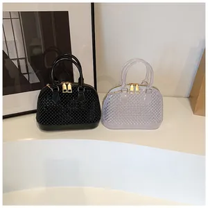 Detail of jelly shell bags showing diamond texture and gold chain in black and clear