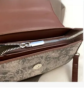 Detail view of smooth silver zipper and interior lining of vintage printed handbag