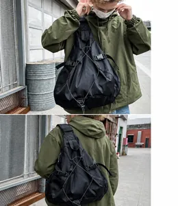 Detalle de bandolera techwear negra con cordón elástico y bolsillo de malla