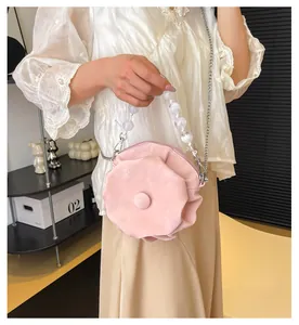 Detail of pink floral petal handbag with pearl handle and soft velvet texture