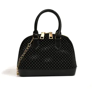 Close-up of black beaded shell-shaped bag with gold chain and handle details