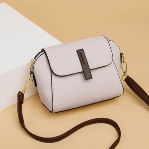 Borsa a tracolla minimalista in pelle rosa con finiture marroni e dettagli dorati