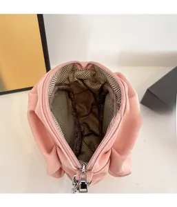 Detail view of pink pleated cloud bag interior showing smooth zipper and herringbone lining