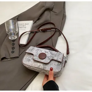 Detail of vintage patterned tote bag with large brown button and leather strap