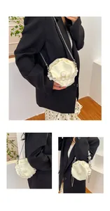 Close-up of beige pleated round cloud bag with faux pearl handle and silver chain strap
