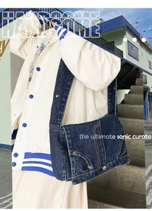 Vue détaillée du sac bandoulière en denim bleu délavé avec surpiqûres et large bandoulière