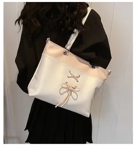 Detail view of pink and white contrast tote bag with ballet bow ribbon decoration