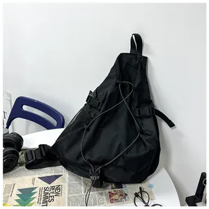Detailed close-up of a black tactical crossbody bag with bungee cords and utility mesh pocket