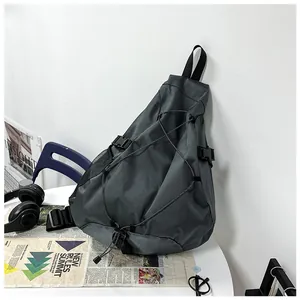 Men's crossbody bag with elastic storage cords and side mesh pocket on a white desk