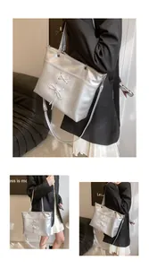 Detail of silver metallic tote bag with decorative cross-lacing and bow elements