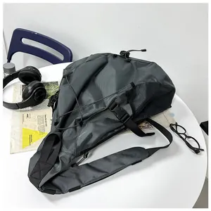 Detailed view of dark grey nylon crossbody bag with elastic cords and mesh side pocket