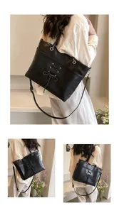 Detail of black tote bag with bow ribbons, dual handles and adjustable strap view