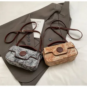 Detail view of retro floral print crossbody bags in grey and brown color options