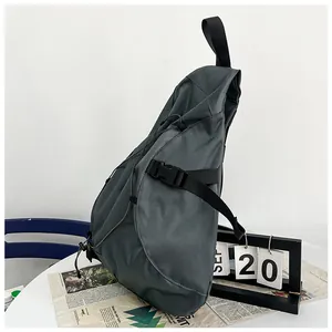 Macro detail of dark grey nylon shoulder bag featuring adjustable buckle and zip pockets